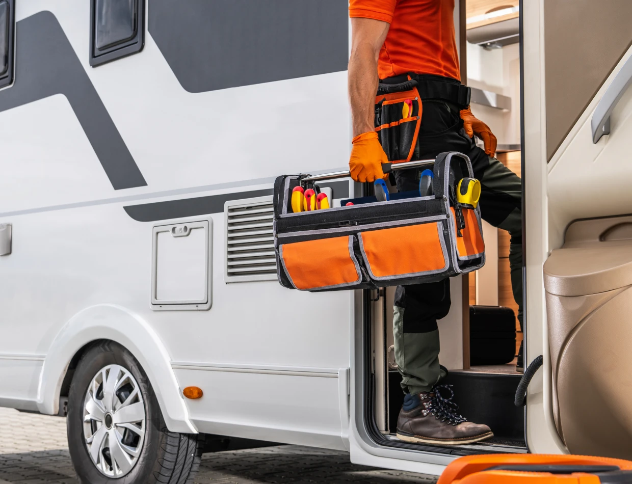 Technician entering RV with tool bag